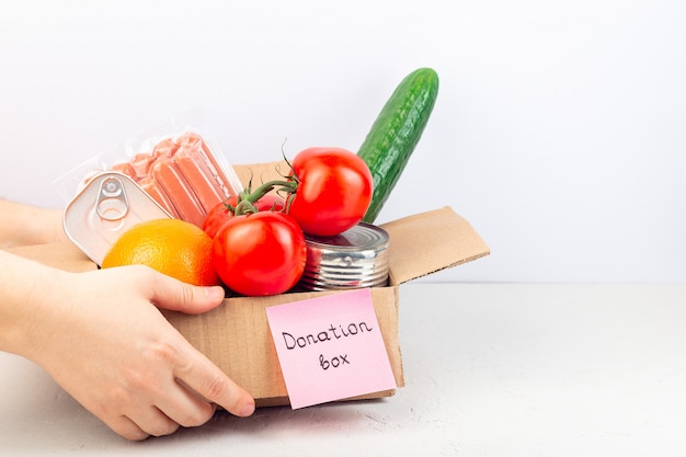 Food donation or delivery at home, hands give or take carton box with food