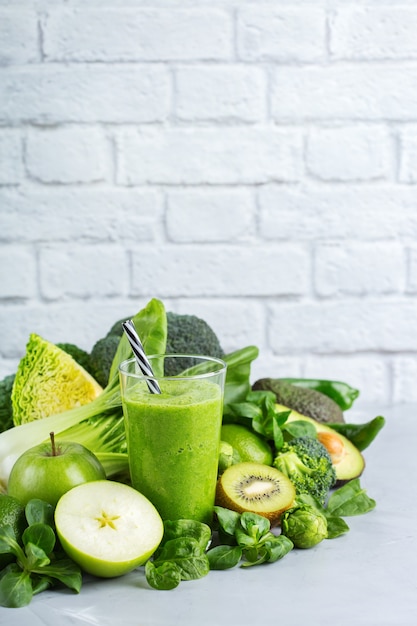 Food and drink, healthy dieting and nutrition, lifestyle, vegan, alkaline, vegetarian concept. Green smoothie with organic ingredients, vegetables on a modern kitchen table. Copy space background