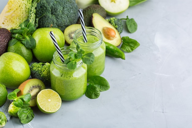 Food and drink, healthy dieting and nutrition, lifestyle, vegan, alkaline, vegetarian concept. Green smoothie with organic ingredients, vegetables on a modern kitchen table. Copy space background