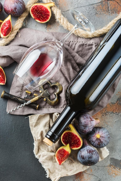 食べ物や飲み物の静物の休日季節の収穫秋秋のコンセプトボトルコルク栓抜きコルク赤ワインのグラスとグランジテーブルのイチジクスペースの背景をコピー