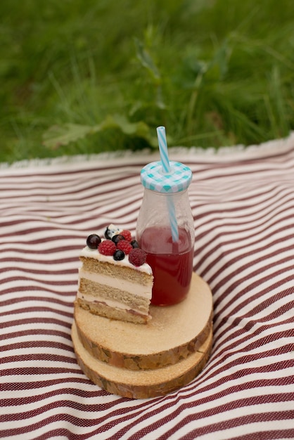 Food and drinks on a striped blanket, in summer on the grass