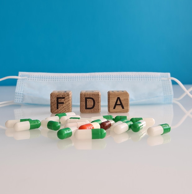 Foto food and drug administration maschera protettiva medica e pillole concetto di approvazione dei farmaci fda