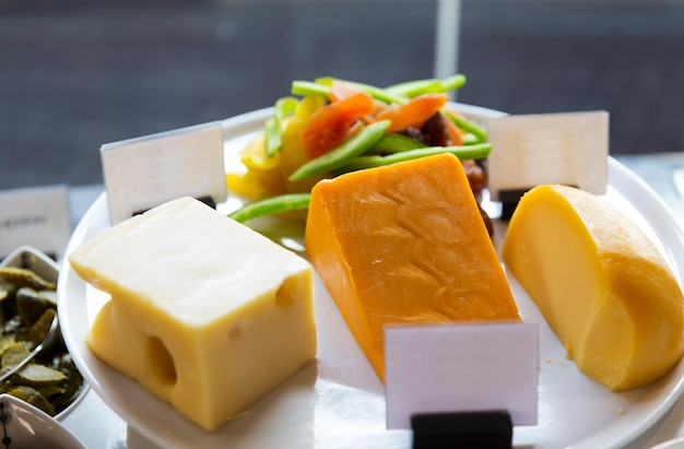 food, and eating concept - close up of cheese on showcase at cafe