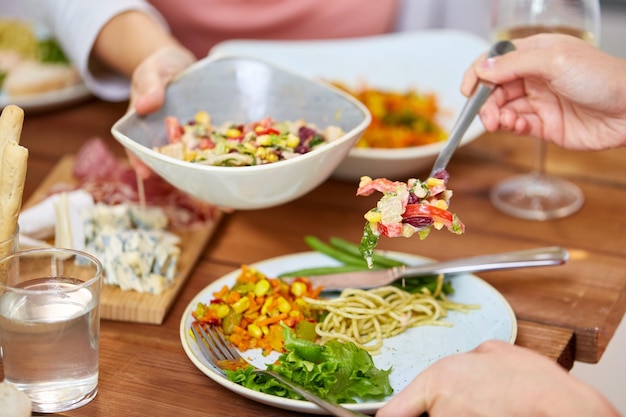 food eating and leisure concept people with salad having dinner