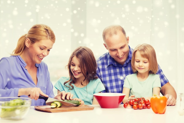 食べ物、家族、子供、幸福と人々の概念-家で夕食を作る2人の子供を持つ幸せな家族