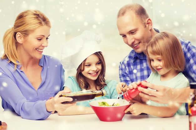 food, family, children, happiness and people concept - happy family with two kids making salad for dinner at home