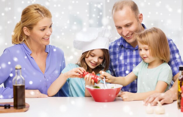 food, family, children, happiness and people concept - happy family with two kids making salad for dinner at home