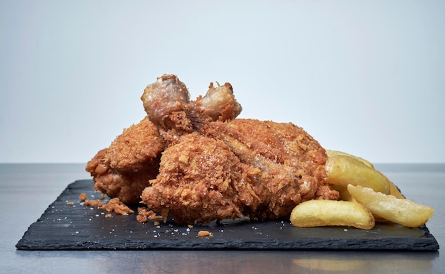 FOOD fried chicken legs served with French fries in a restaurant