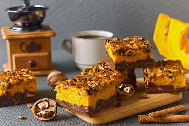 Food for Halloween. Homemade chocolate brownie with nuts and a layer of pumpkin. Coffee with cakes