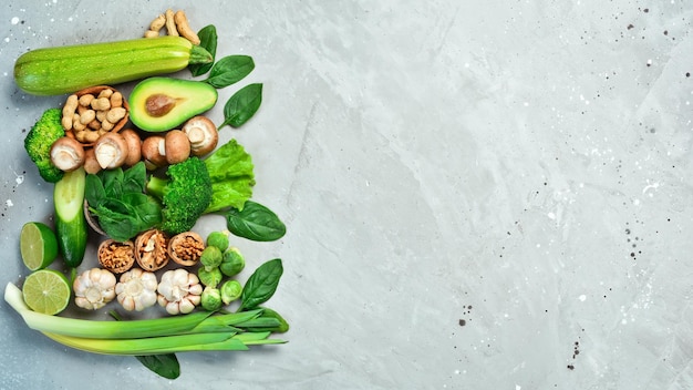 Food for heart health Green vegetables fruits nuts and mushrooms On a gray stone background Top view