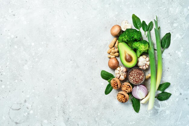 Food for heart health Green vegetables fruits nuts and mushrooms On a gray stone background Top view