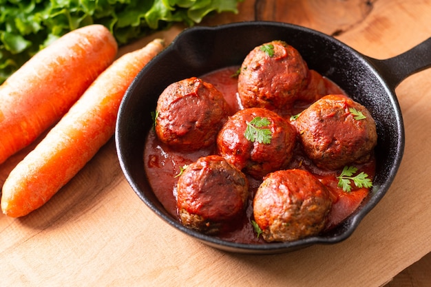 Food Homemade organic spicy meatball in iron cast on wooden background