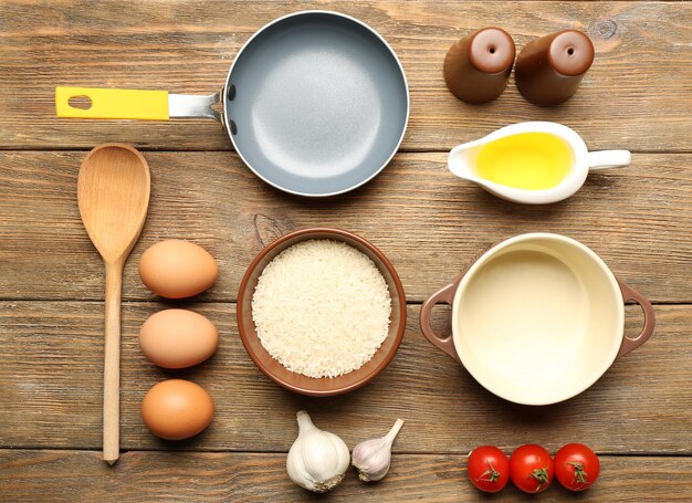 Food ingredients and kitchen utensils for cooking on wooden background