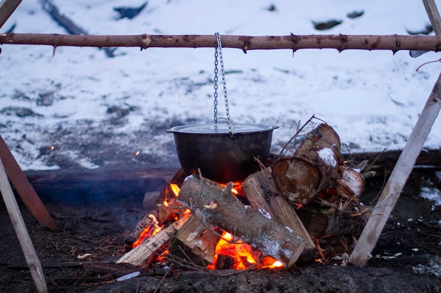 Food is prepared in a cauldron on an open fire rest in the evening in nature