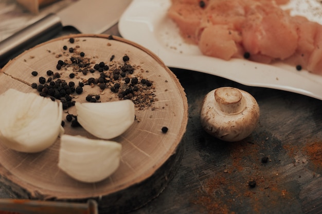 еда на кухне мясо грибы лук специи на деревянном ломтике