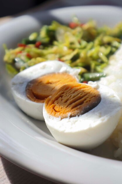 Foto menu di cibo riso verdure kates fiori con un piatto di uova bollite che sono state divise