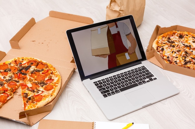 food order concept. Close-up top view of a ordering pizza with a laptop. all screen graphics are made up.