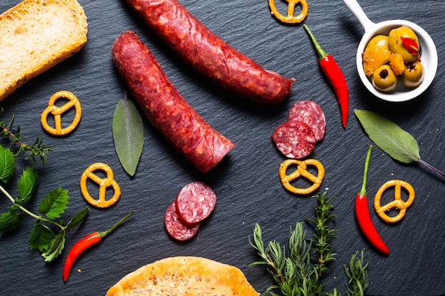 Food party with different kinds of meat and homemade bread on black slate stone