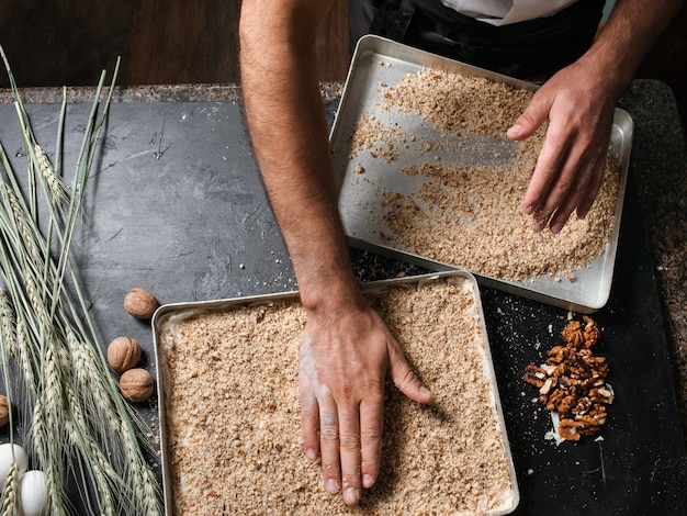 Photo food pastry dessert recipe concept. chef making baklava with nuts at restaurant.