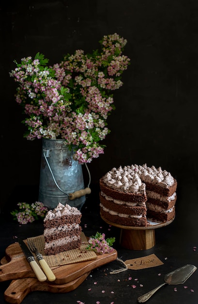 Food photography of chocolate cake, flowers, black background, rustic, vintage