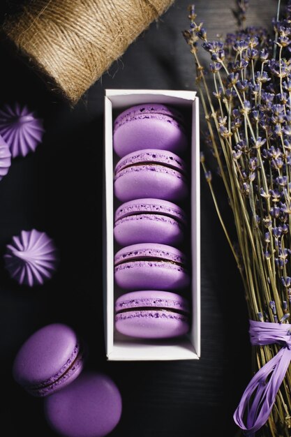 Food photography Macaroon purple with chocolate filling on a black wooden background