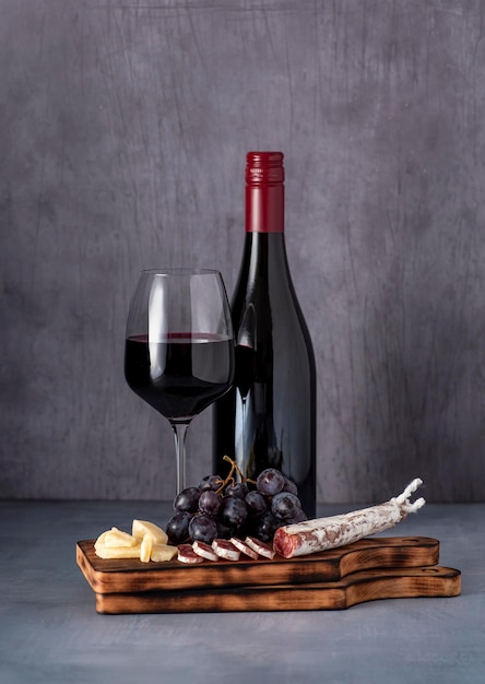 Food photography of red wine cheese grape salami