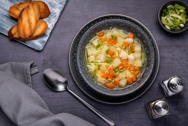 Food photography of soup with noodle chicken and potato