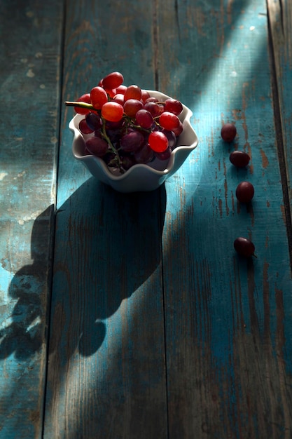 Food photography there are some fresh and delicious red grapes on the plate on the blue table