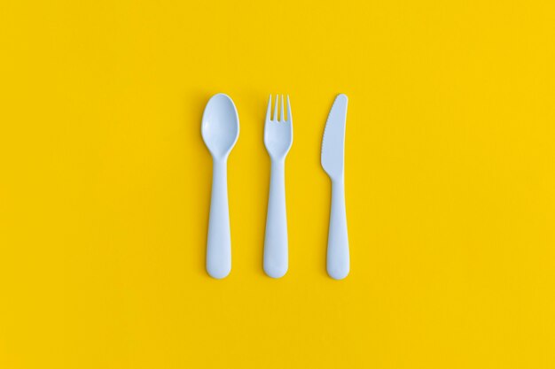 黄色の背景に食品プラスチック包装。プラスチックとエコロジーのリサイクルの概念。