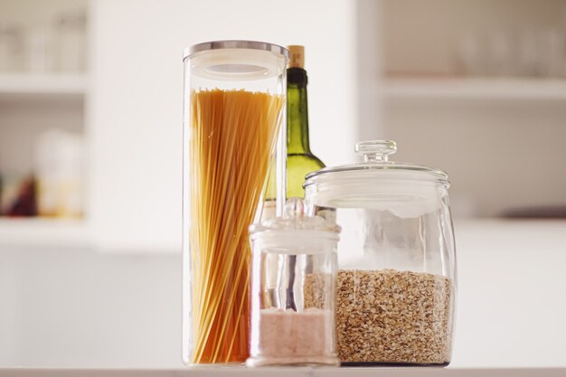 Food products in glass jars in the kitchen pasta cereal salt wine groceries