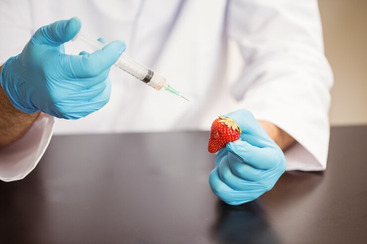 Photo food scientist injecting a strawberry