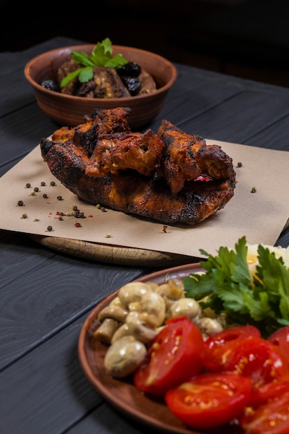 Food set with grilled pork ribs on black wooden background