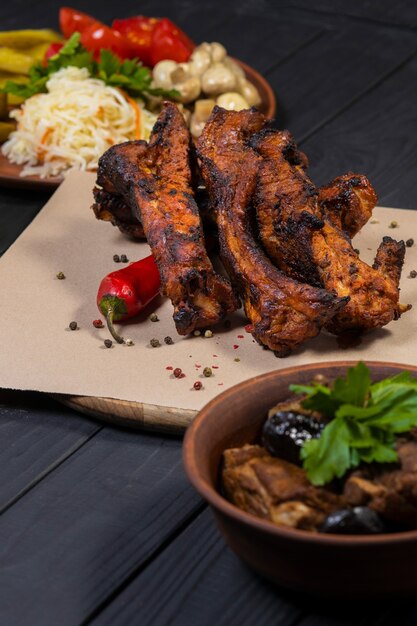 Food set with grilled pork ribs on black wooden background