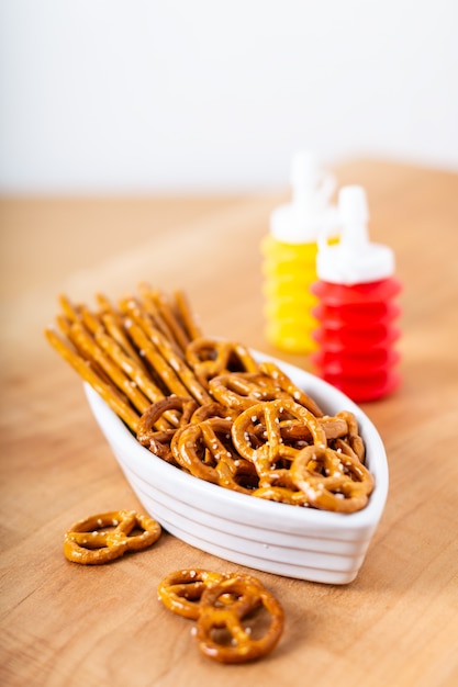 Food snack Salted crispy Pretzel in ceramic boat on wood board with copy space