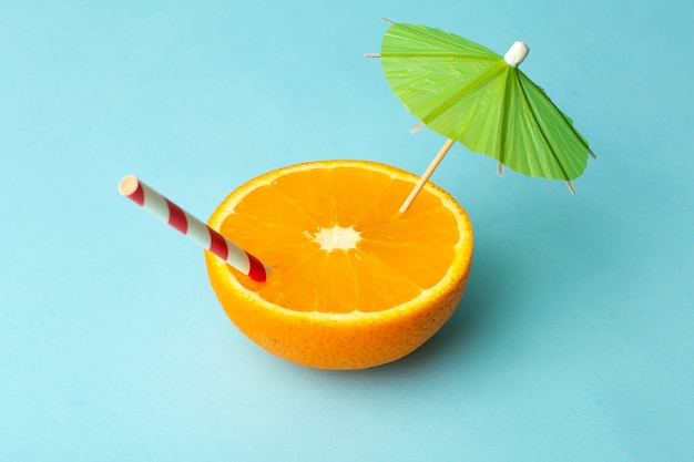 Food summer minimal concept. Orange juice and juicy tropical fruits on a light colored background