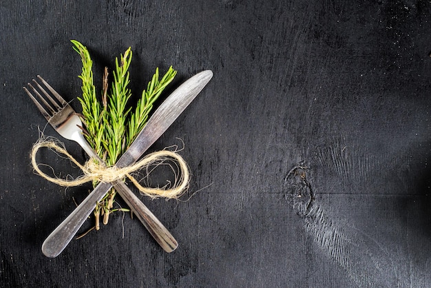Food tools with herbs on black background