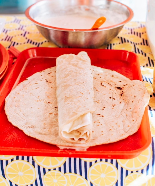 Food Traditional Large Quesillo served on table Nicaraguan cheese made and served on the table Traditional cheese with pickled onion and wrapped tortilla Traditional Nicaraguan Quesillo