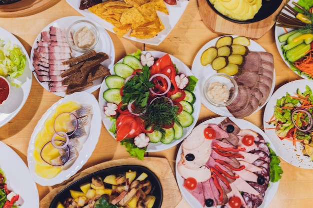 맛있는 살라미 소시지, 슬라이스 햄, 소시지 및 샐러드와 음식 트레이. 테이블에서 선택과 고기 플래터입니다.