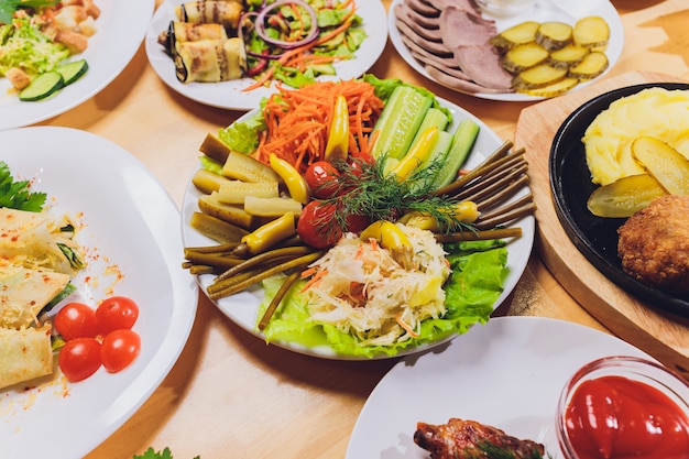 Food tray with delicious salami, pieces of sliced ham, sausage and salad