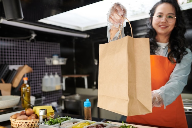 Food Truck Worker Giving Paper Bag