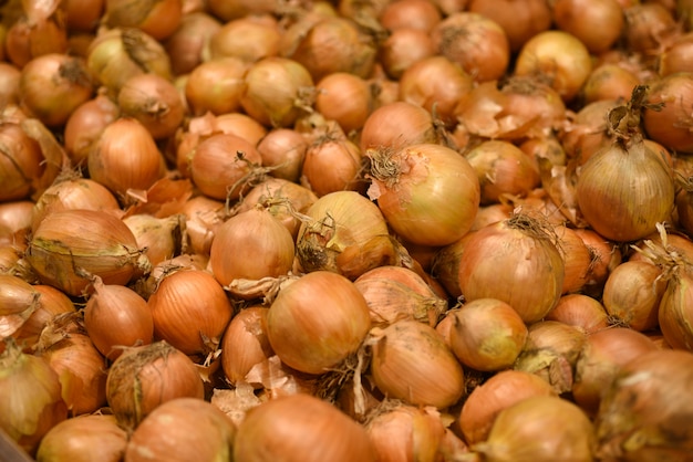 Fondo fresco delle cipolle dorate delle verdure dell'alimento. modello di cipolle per la vendita nel mercato