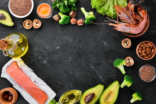 Cibo con vitamina naturale omega 3 cibo sano pesce gamberetti broccoli noci di lino uova prezzemolo vista dall'alto spazio libero per il testo su sfondo nero