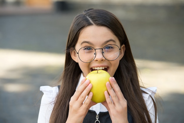 あなたの歯のための食物。小さな子供は屋外でリンゴを噛みます。学校のおやつ。健康的な食事。患者教育。歯の健康。口腔衛生。虫歯や虫歯の予防。小児歯科。