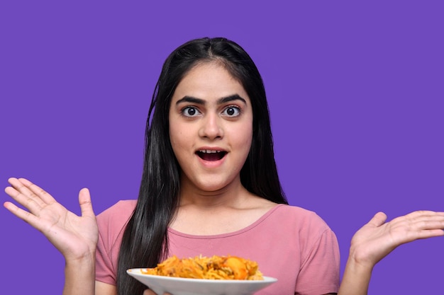 Foodie girl shocking and posing over purple background indian pakistani model