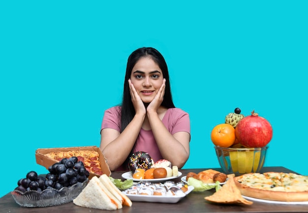 foodie girl sitting at fruit table smiling and hands on table looking front indian pakistani model