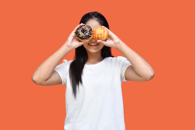 foodie-meisje met een wit t-shirt dat de ogen bedekt met donut en pasteitjes indiaans pakistaans model