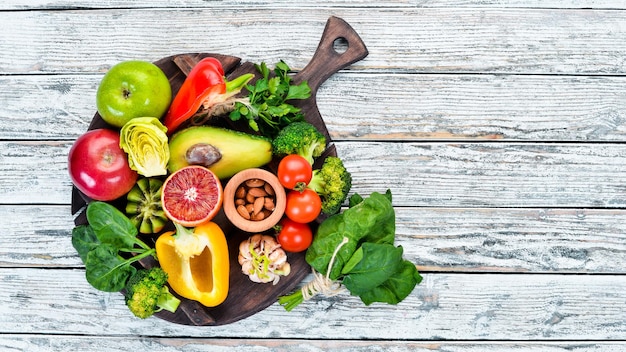 Photo foods containing natural fiber avocados kiwi apple tomatoes spinach paprika orange lemon top view free space for your text on a white background