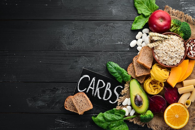 Foto alimenti ricchi di carboidrati pane pasta farina di avocado zucca broccoli fagioli spinaci il concetto di un'alimentazione sana su sfondo nero