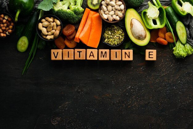 Foods rich in vitamin E pumpkin broccoli dried apricots parsley avocado and vegetables The inscription Vitamin E Top view