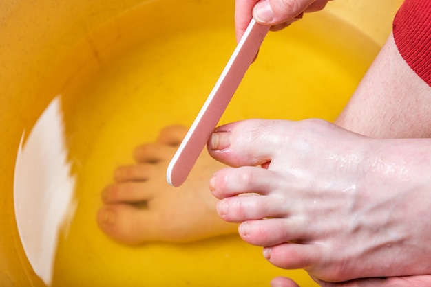 Foot baths. Care for skin and nails on feet and heels. Filing of the toenails.